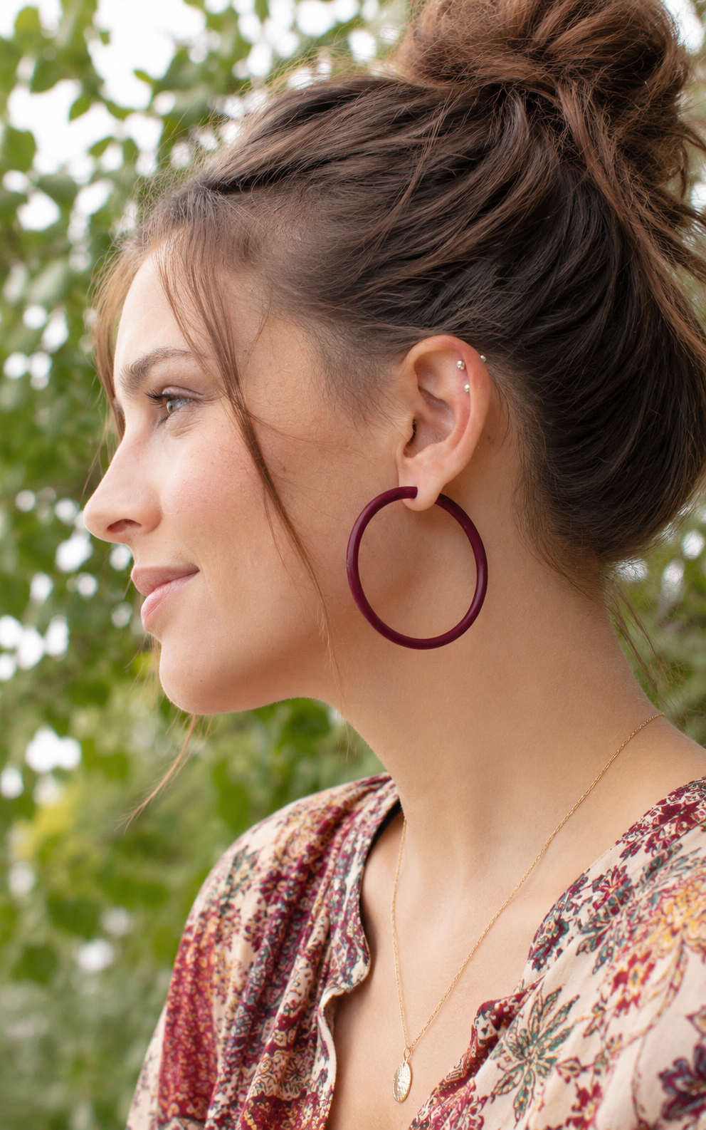 Jeune femme et anneaux d'oreille ultralegers coueur aubergine.