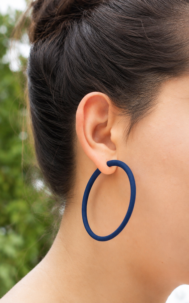 Jeune femme cheveux bruns et anneaux doreilles indigo