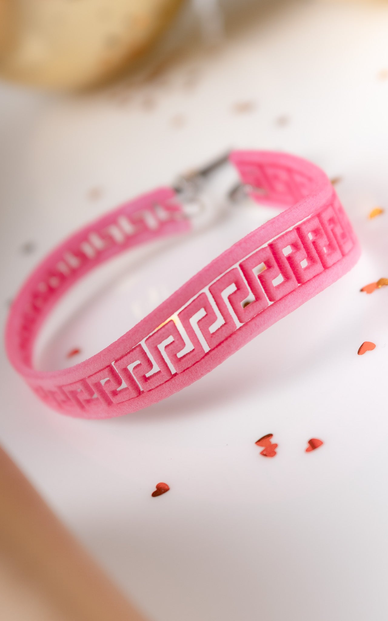 Bracelet ou est découpé le logo de la clé de l'infini grecque. couleur rose. 