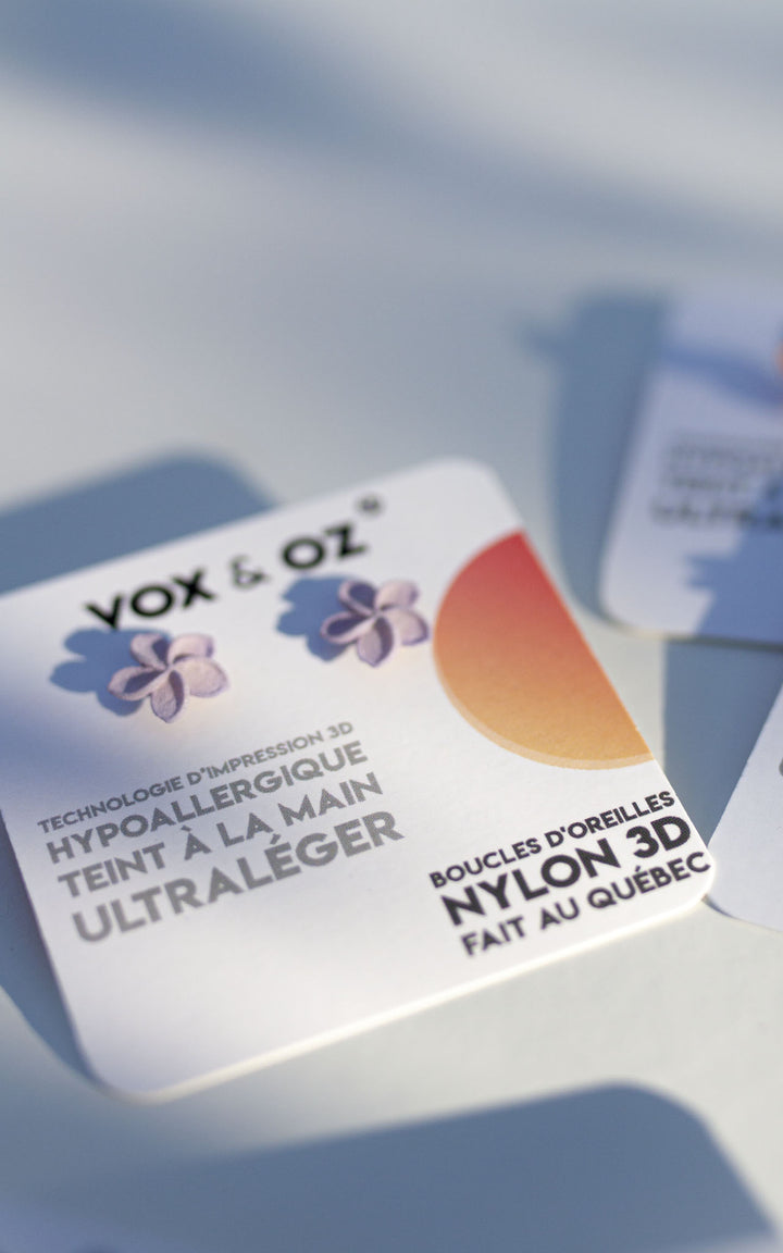 Puces d’oreilles OHANA lilas Vox & Oz – bijoux floraux 3D en nylon recyclé, posées sur fond blanc