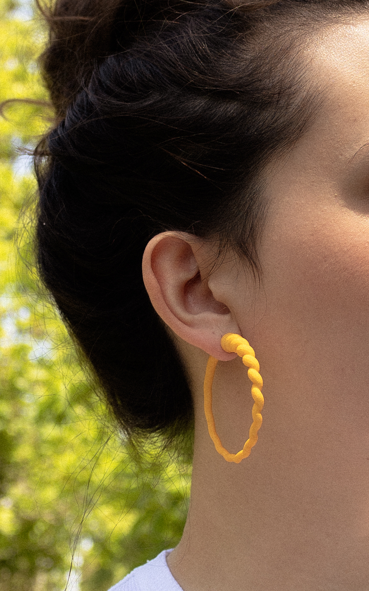 Jeune femme et anneaux d'oreilles couleur mango