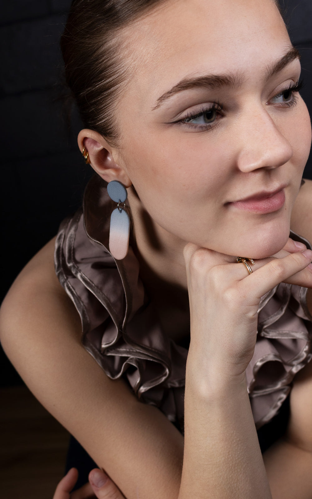 Femme portant des boucles d’oreilles longues ultralégères en nylon recyclé imprimé 3D, dégradé pêche et bleu, design contemporain Vox & Oz