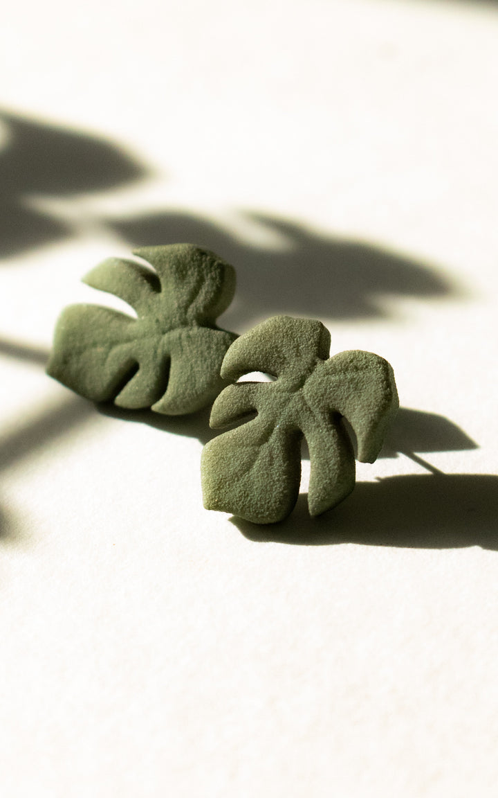 Vue de face des puces d’oreilles en forme de feuille de Monstera, modèle MAUI. Leur design épuré met en valeur les nervures stylisées de la feuille, symbole de fraîcheur et de style botanique.
Chaque boucle est imprimée en 3D à partir de nylon recyclé, puis teintée à la main dans une douce teinte de vert végétal. Un bijou minimaliste, ultraléger et fait au Québec, parfait pour un look naturel et contemporain.