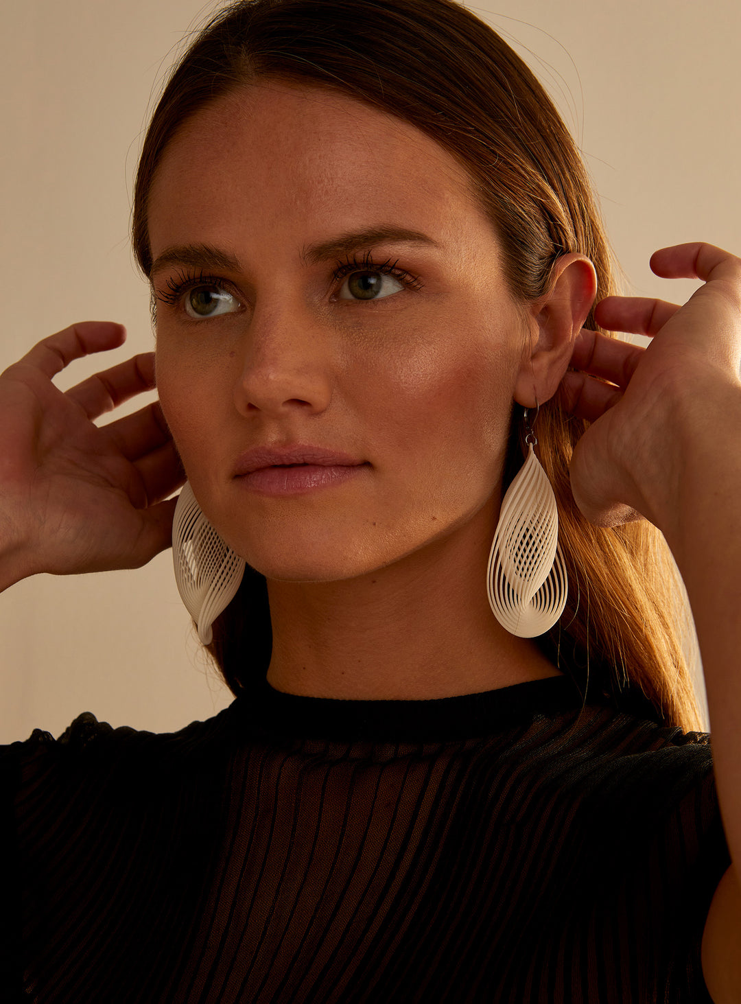Portrait d’une femme portant les boucles d’oreilles OASIS ivoire ultralégères au design sculptural imprimé 3D signé Vox &amp; Oz