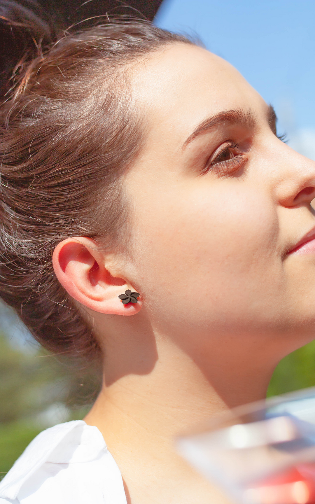 Jeune femme portant les puces OHANA de Vox & Oz – boucles d’oreilles florales 3D inspirées de la fleur de plumeria, bijoux faits au Québec