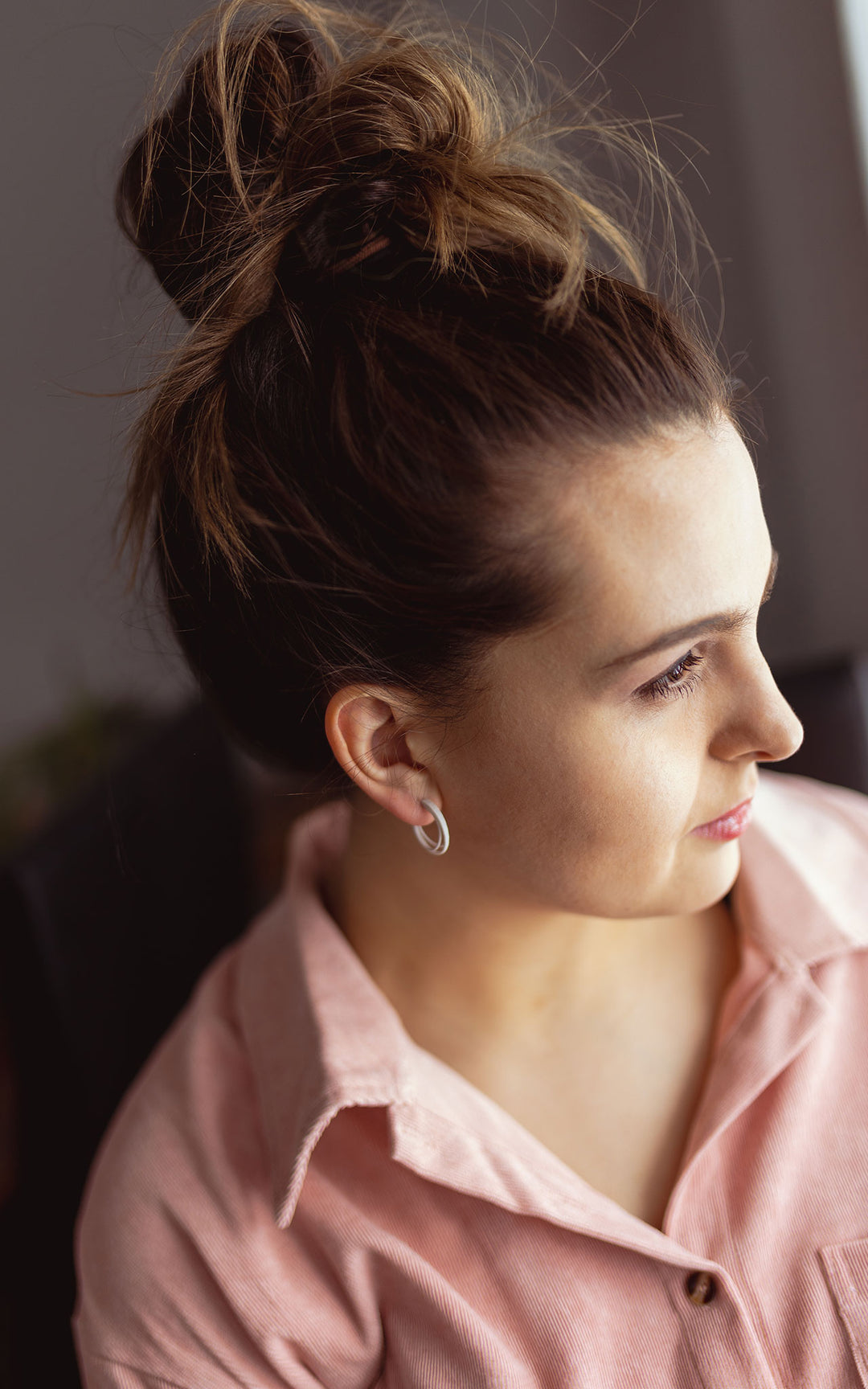 Jeune femme portant les petits anneaux d'oreilles CASPER blancs de Vox & Oz. Fabriqués au Québec en nylon recyclé teint à la main, ces anneaux de 2 cm sont ultralégers, hypoallergéniques et parfaits pour le quotidien.